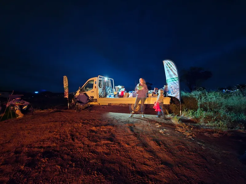 A ute used as the auction stage beneath a dark blue evening sky