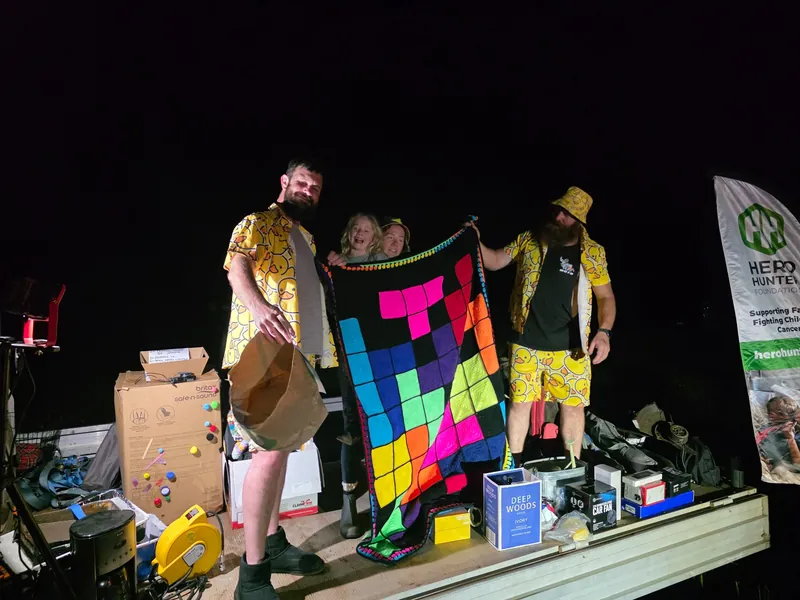A colourful handmade blanket held up during the auction