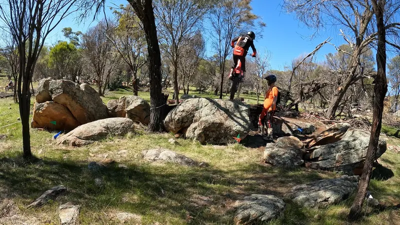 Pathfinders rider clearing a rock obstacle in a trials section