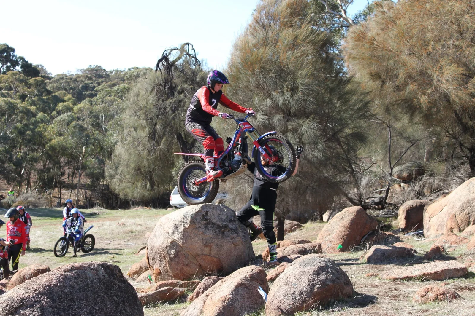 Young trials rider lifting the front wheel over a rock at a Pathfinders event