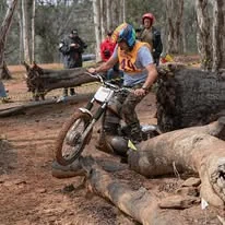 Trials competitor riding through technical natural terrain at the 2025 WA State Championships