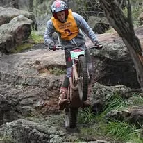 Trials rider balancing through a championship section in Western Australia